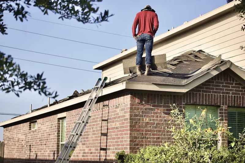 Professional roofer working on a residential roof in Round Top Manor